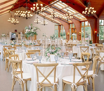 A large room with tables, settings and chairs